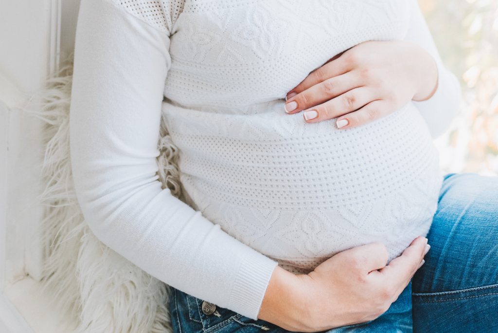 Schwangere Frau, die sich den Bauch hält